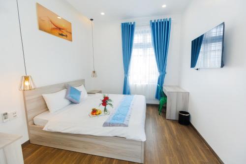 a bedroom with a bed with a tray of fruit on it at Lee House Villa Tam Thanh in Tam Ky