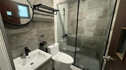 a bathroom with a toilet and a sink and a shower at Tianshe Xiangsui B&B in Hualien City