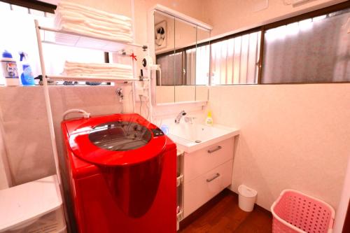 a small bathroom with a red machine in it at 民泊優雅 in Izumi-Sano
