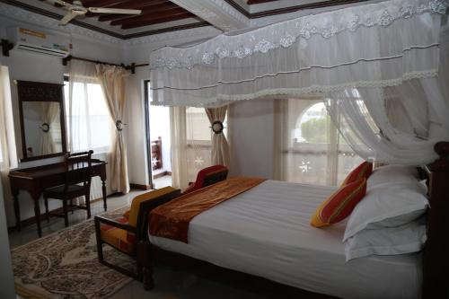 a bedroom with a bed with a canopy and a piano at Beytul Habaib in Lamu