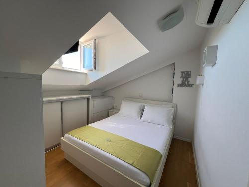 a small bedroom with a bed in a attic at City Apartments Nada in Makarska