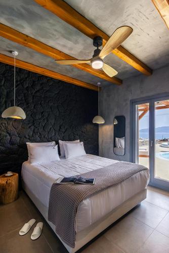 a bedroom with a bed and a ceiling fan at Osmio Luxury Residence in Adamantas