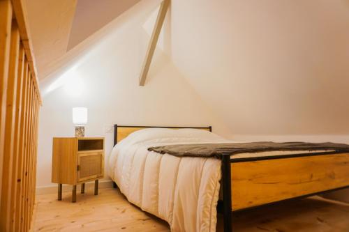 a bedroom with a bed and a night stand at -LE CHALET- Joli cocon au centre de Concarneau in Concarneau