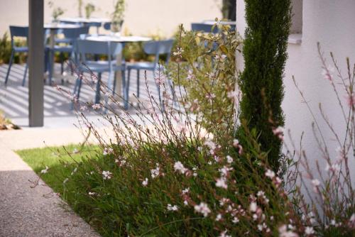a patch of grass with flowers next to a tree at Falena Luxury Rooms in Kalyves Poligirou