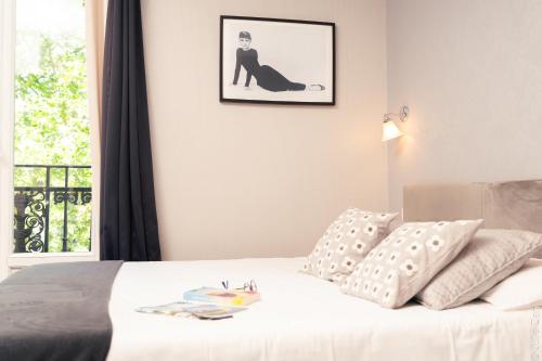 a bedroom with a bed with a picture on the wall at Hotel Mirabeau in Tours