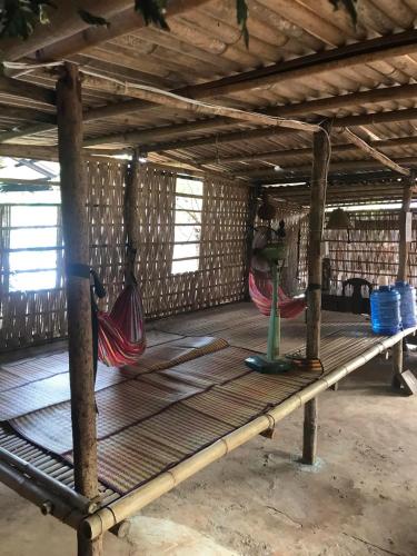 a room with two hammocks on a wooden floor at Happy Homestay Banlung & Trekking in Banlung