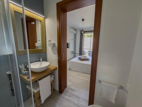 a bathroom with a sink and a bathroom with a bed at Calascoglietti in Stintino