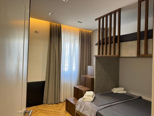 a bedroom with a bed and a window at The Loft Luxury Apartment in Shkodër