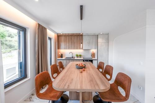 a dining room with a wooden table and chairs at Azzurea Residence in Zaton