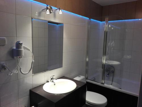 a bathroom with a sink and a shower and a toilet at Willa REIMERS in Krynica Morska
