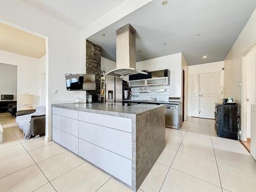 une grande cuisine avec des placards blancs et un grand îlot dans l'établissement Grand appartement Ajaccien - Ultra Centre & Parking - Les Frères de la Loc', à Ajaccio