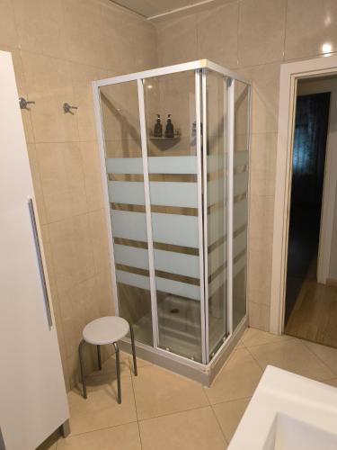 a glass shower in a bathroom with a stool at Piso Ponferrada in Ponferrada