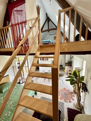a wooden staircase in a room with a living room at Gite Cosy Forme et Bien-etre in Masseret