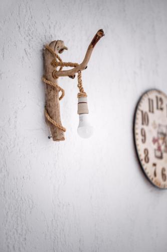 a light on a wall next to a clock at Brunis Apartments in Nei Poroi