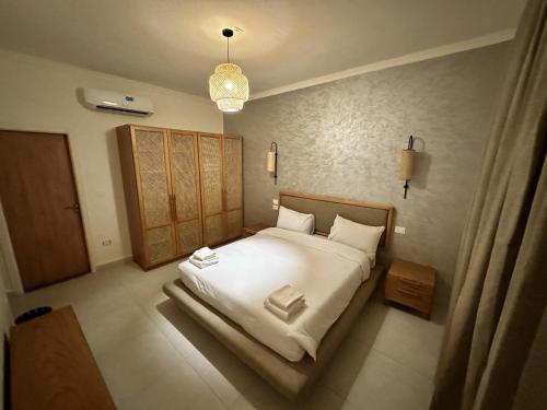 a bedroom with a bed with white sheets and pillows at Ios Hotel & Village Extension in El Alamein