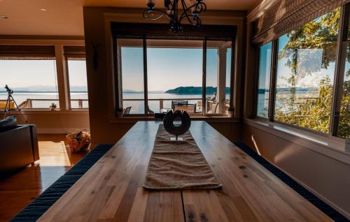 sala de estar con mesa de madera y ventanas en Stunning House with Views of Puget Sound! Ideal for Family Reunions, en Edmonds