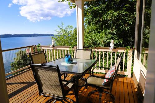 una mesa y sillas en un porche con vistas al agua en Stunning House with Views of Puget Sound! Ideal for Family Reunions, en Edmonds