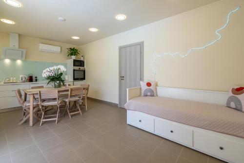 a bedroom with a bed and a table and a kitchen at Modular Bungalows With Heated Pool Artemis Greece in Artemida