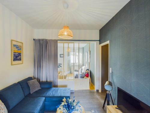 un salon avec un canapé bleu et une fenêtre dans l'établissement -ALYS- Charmant T2 proche plage, à Concarneau