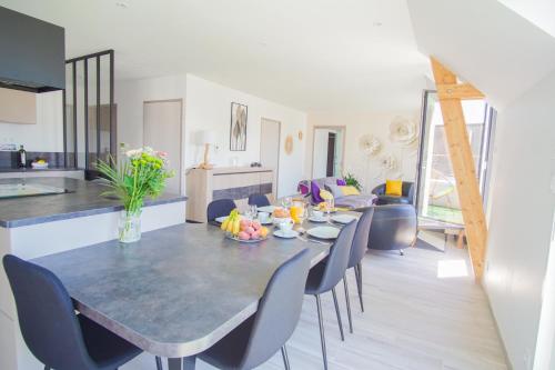 une salle à manger et un salon avec une table et des chaises dans l'établissement -FULL- Magnifique T3, terrasse vue mer et garage, à Concarneau