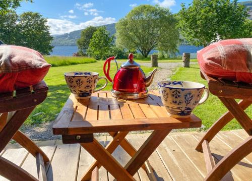 einen Holztisch mit Wasserkocher und Tassen darauf in der Unterkunft Seal Cove Cabin - Luxury Glamping in Cairndow