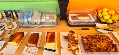 a table topped with lots of different types of food at Hotel Cala di l'Oru in LʼÎle-Rousse