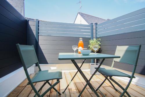 une table et des chaises sur une terrasse avec une clôture dans l'établissement -PICCO VERDE- Appartement avec balcon - Concarneau, à Concarneau