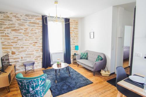 un salon avec un canapé et une table dans l'établissement -PICCO VERDE- Appartement avec balcon - Concarneau, à Concarneau