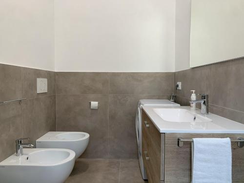 a bathroom with two sinks and a toilet at Stretti & Distratti - suite home in Putignano