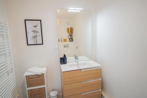 une salle de bain avec un lavabo et un miroir dans l'établissement -SHELBY- T2 Arriere corniche parking et terrasse, à Concarneau