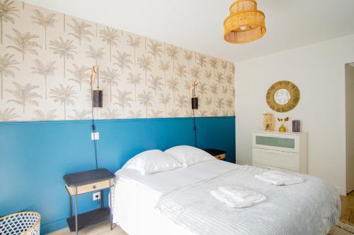 une chambre avec un lit avec un mur bleu dans l'établissement -SHELBY- T2 Arriere corniche parking et terrasse, à Concarneau