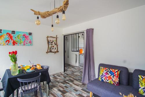 un salon avec une table et un canapé dans l'établissement -SKOL- Charmant T2, proche du centre de Concarneau, à Concarneau