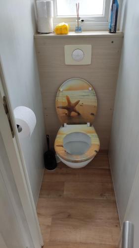 a small bathroom with a toilet with a picture of a beach at Bredene Haus Schildkröte in Bredene