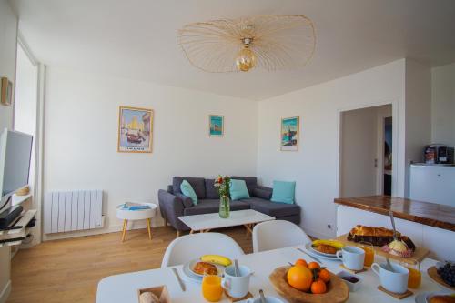 un salon avec une table avec de la nourriture dessus dans l'établissement -PORTO- Elegant T3 avec vue sur la ville-close, à Concarneau