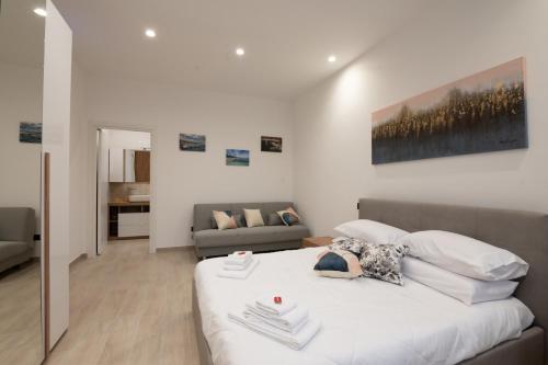 a bedroom with a large white bed and a couch at Da Zia Gina Locazione Turistica in Bisceglie