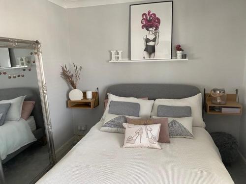 a bedroom with a large bed with a mirror at Room in house with breakfast incuded in Llantwit Major