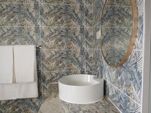 a bathroom with a white sink and a mirror at Leropong Manor in Mahalapye