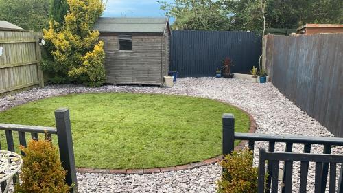 a garden with a small yard with a dog house at Room in house with breakfast incuded in Llantwit Major