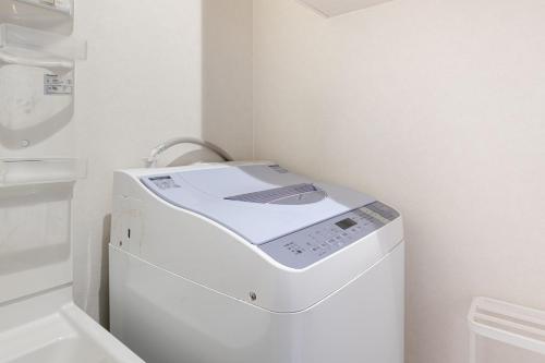 a white washer and dryer in a bathroom at Komachi Hotel Nipponbashi in Osaka