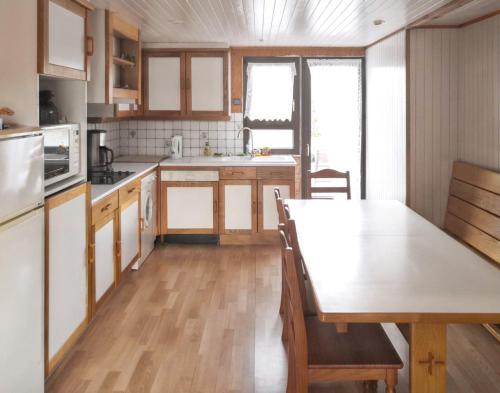a kitchen with a wooden table and a kitchen with a dining table at Chalet d'une chambre avec terrasse amenagee a Giffaumont Champaubert in Giffaumont