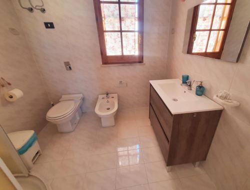 a bathroom with a toilet and a sink and a toilet istg at Villa Migliore in Lampedusa