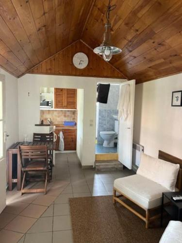 un salon avec une table et une cuisine avec un plafond dans l'établissement Typique maison de pêcheur, au Le Verdon-sur-Mer