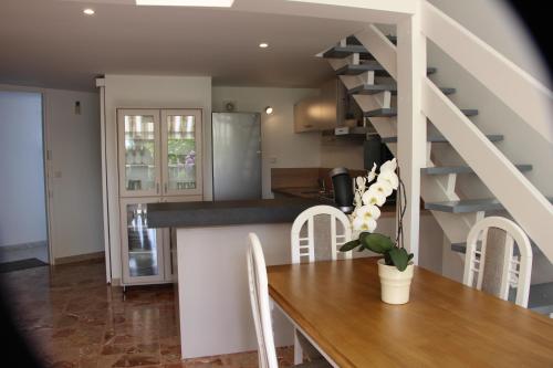 une cuisine et une salle à manger avec une table et un escalier dans l'établissement Duplex à 100 m de la plage, à Grosseto-Prugna