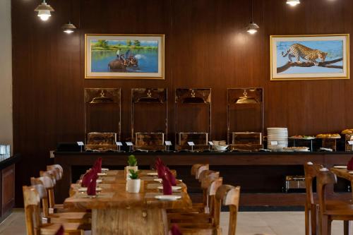 a dining room with a table and chairs with plates at River Bank Jungle Resort, Chitwan in Bharatpur