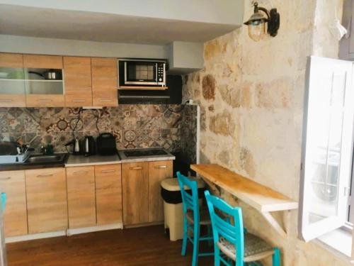 a kitchen with wooden cabinets and blue chairs at Hippie City Hostel in Chania Town