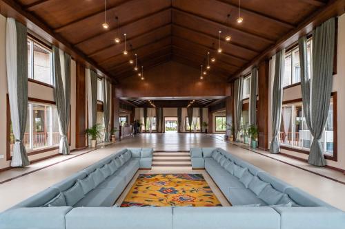 a large hall with a blue couch in a building at River Bank Jungle Resort, Chitwan in Bharatpur