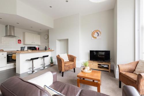 a living room with a couch and a table at Red Lea Apartments with Pool & Spa Access in Scarborough