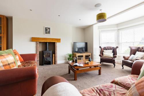 a living room with couches and a tv and a fireplace at Red Lea Apartments with Pool & Spa Access in Scarborough