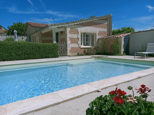 a swimming pool in front of a house at Gîte Lachevalle in Saint-Jean-dʼAngély