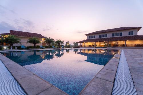 a swimming pool in front of a building at River Bank Jungle Resort, Chitwan in Bharatpur